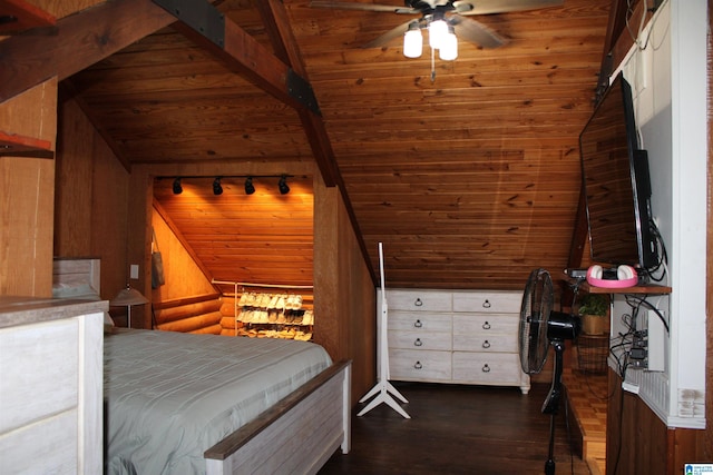 bedroom with dark wood-type flooring, track lighting, wood walls, and vaulted ceiling