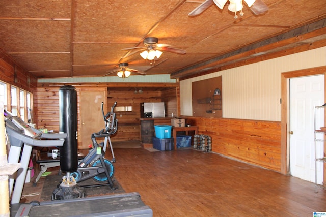 exercise area with wood walls, ceiling fan, and hardwood / wood-style floors