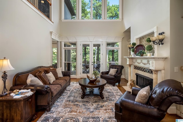 living room featuring dark hardwood / wood-style floors, a wealth of natural light, a fireplace, and french doors