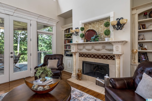 living area with french doors, a fireplace, and light hardwood / wood-style flooring