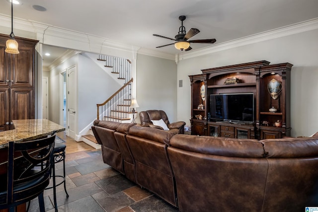 living room with ornamental molding and ceiling fan