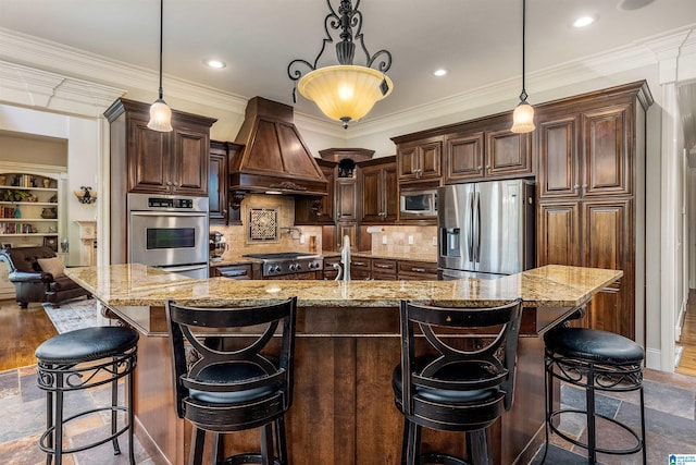 kitchen with pendant lighting, dark brown cabinets, appliances with stainless steel finishes, and custom exhaust hood