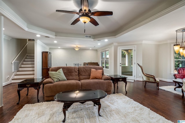 living room featuring dark hardwood / wood-style floors, ceiling fan, a tray ceiling, and crown molding