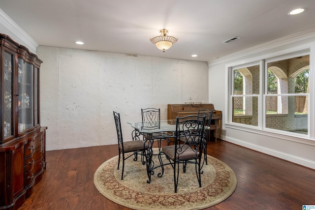 dining area with ornamental molding and dark hardwood / wood-style floors