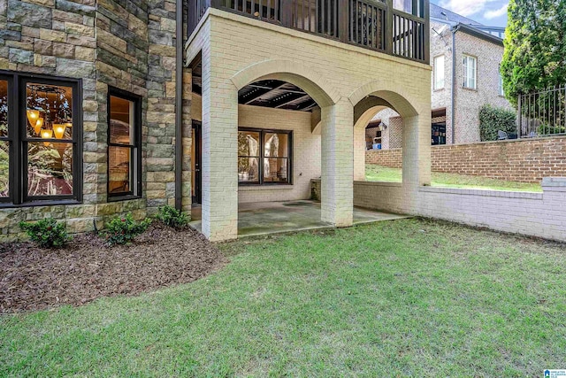 property entrance featuring a patio and a lawn