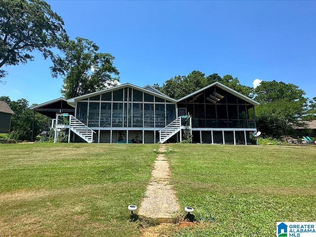 back of property with a yard and a sunroom