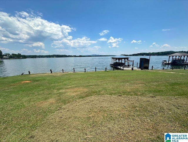 dock area featuring a lawn and a water view