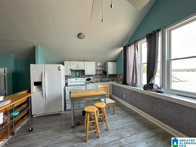 kitchen featuring vaulted ceiling, sink, white cabinets, light hardwood / wood-style floors, and white appliances