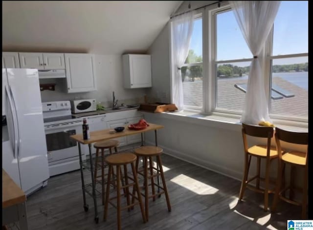 kitchen with white cabinetry, white appliances, dark wood-type flooring, and a water view