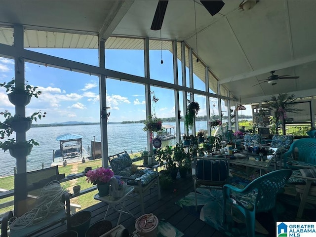 interior space featuring a water view, ceiling fan, and vaulted ceiling with beams