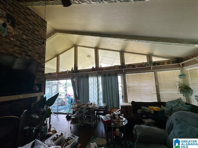 living room with vaulted ceiling, hardwood / wood-style floors, and a textured ceiling