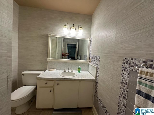 bathroom with vanity, tile walls, tile patterned floors, and toilet