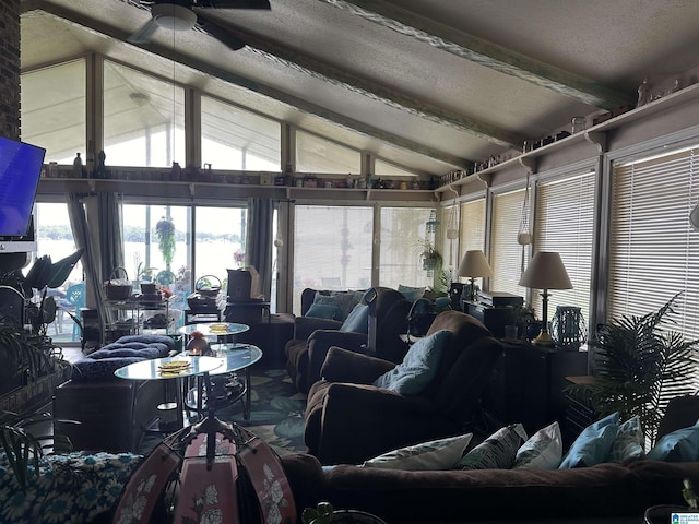 living room featuring ceiling fan, lofted ceiling with beams, and a textured ceiling