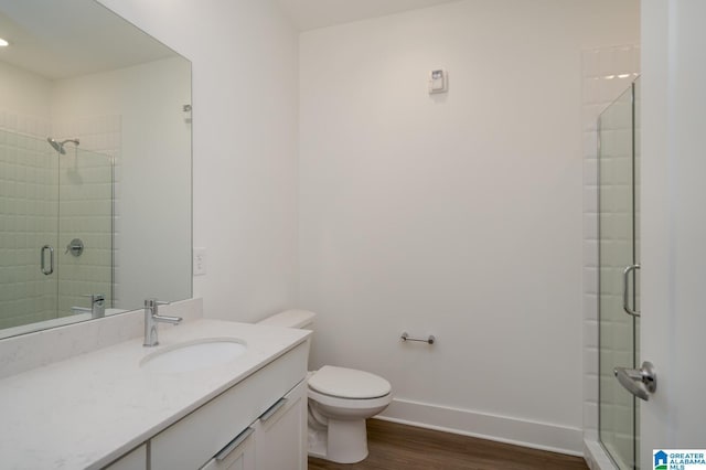 bathroom featuring a shower with shower door, vanity, toilet, and hardwood / wood-style floors