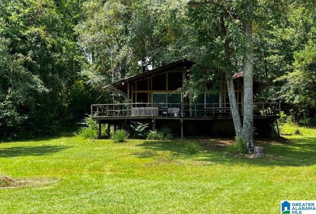 rear view of property featuring a yard and a deck