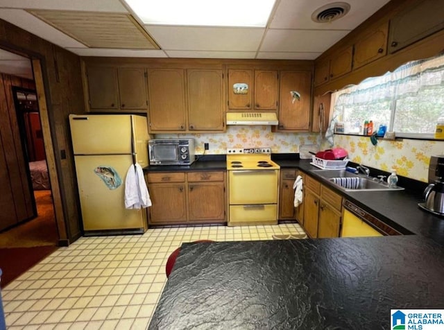 kitchen with sink, a drop ceiling, light tile patterned flooring, and white appliances