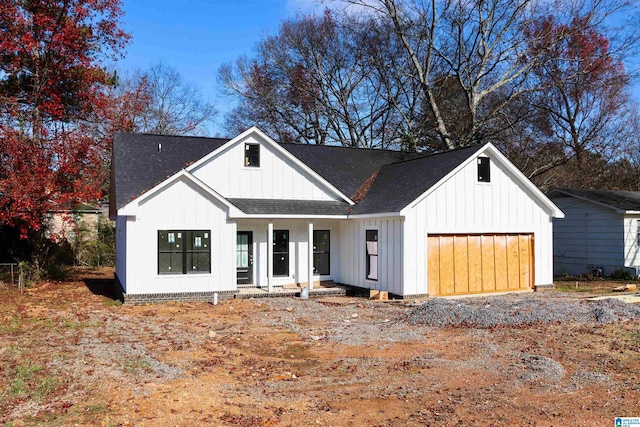 modern inspired farmhouse with a garage and covered porch