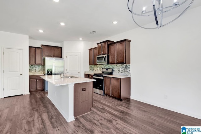 kitchen featuring appliances with stainless steel finishes, an island with sink, and dark wood-type flooring