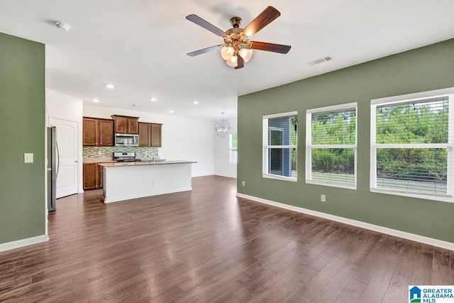 unfurnished living room with dark hardwood / wood-style floors and ceiling fan