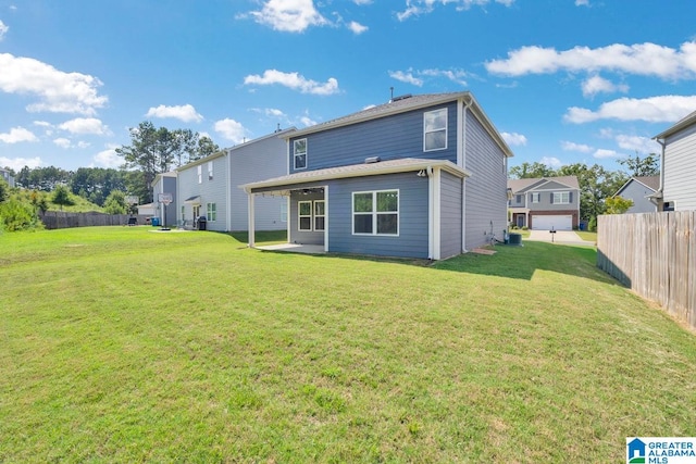 rear view of property with a garage and a yard