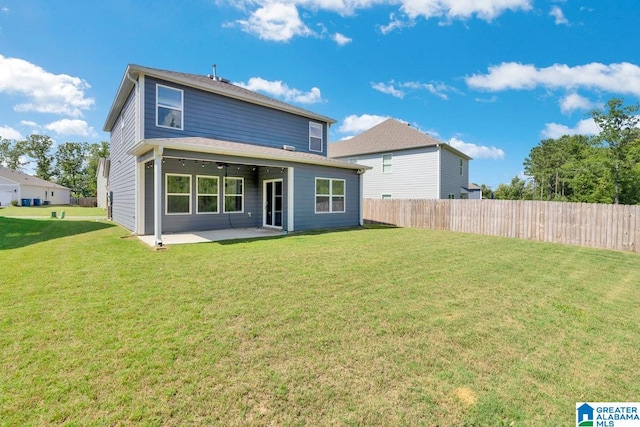 back of house with a patio area and a lawn