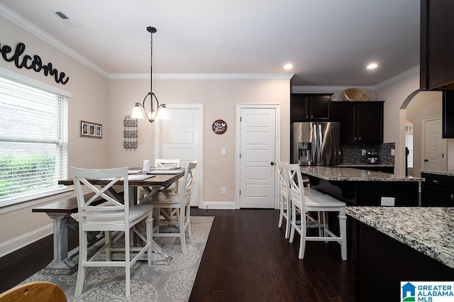 dining space featuring a chandelier, crown molding, and dark hardwood / wood-style floors