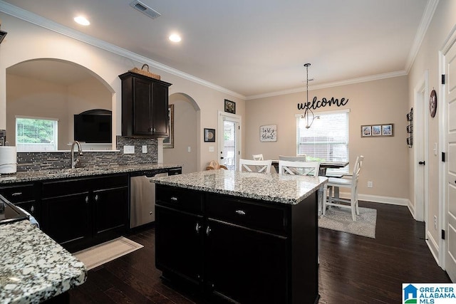 kitchen featuring dishwasher, a center island, pendant lighting, dark wood-type flooring, and decorative backsplash