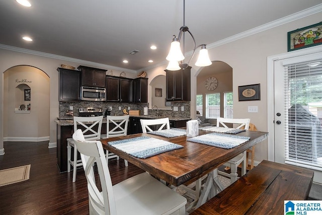 dining room featuring sink, crown molding, and dark hardwood / wood-style floors