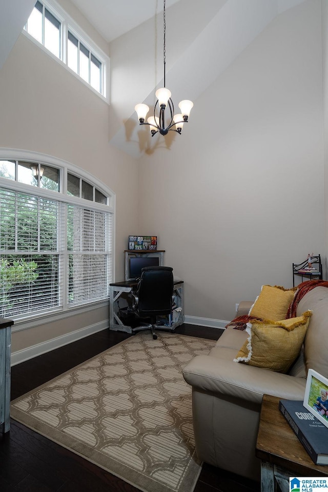 office space with a high ceiling, hardwood / wood-style flooring, a chandelier, and plenty of natural light