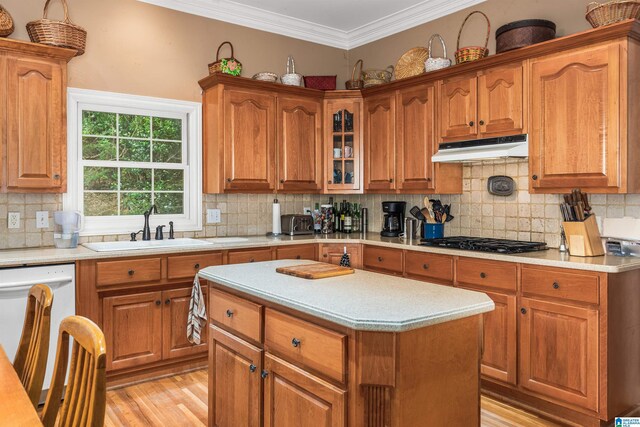 kitchen featuring a center island, decorative backsplash, sink, white dishwasher, and gas cooktop