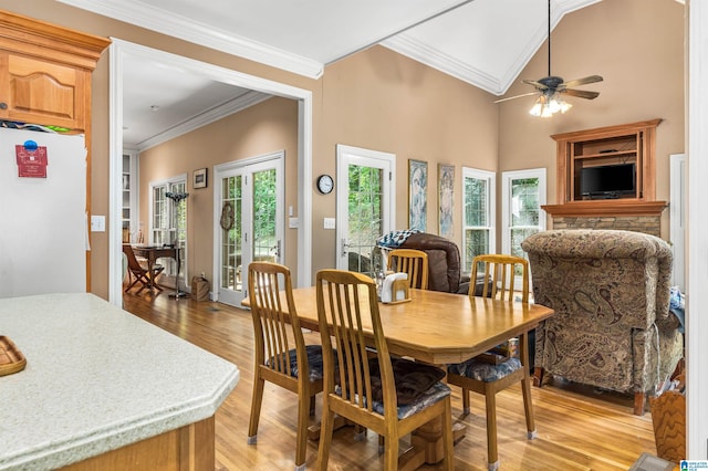 dining area with lofted ceiling, light wood-style flooring, ornamental molding, and a ceiling fan