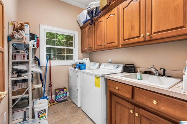 laundry room featuring washing machine and clothes dryer, light tile patterned floors, cabinet space, ornamental molding, and a sink