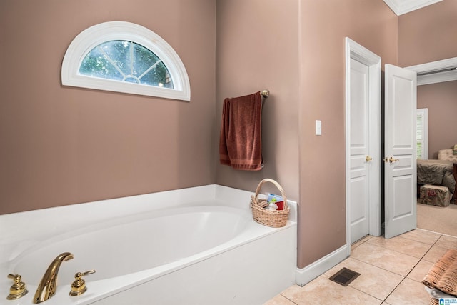 bathroom with tile patterned floors and a tub to relax in