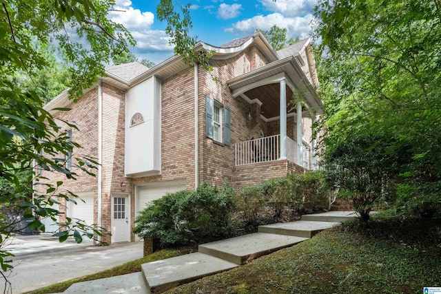 view of property exterior featuring a garage, brick siding, and driveway