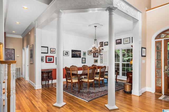 dining space with light wood-type flooring, crown molding, and ornate columns