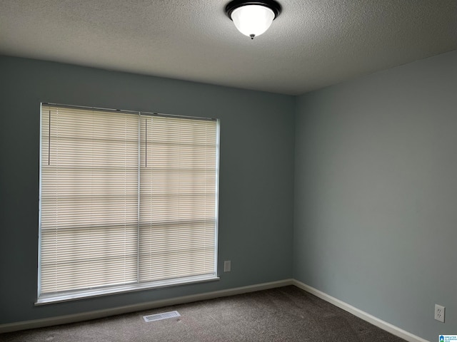 carpeted spare room with a textured ceiling