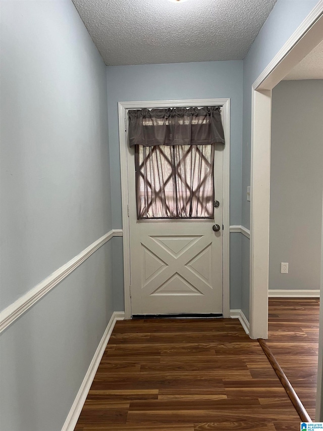 entryway featuring a textured ceiling and dark wood-type flooring