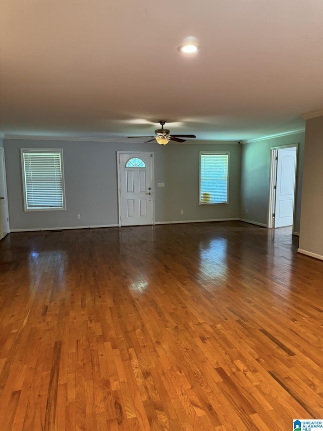 unfurnished living room featuring hardwood / wood-style flooring, ornamental molding, and ceiling fan