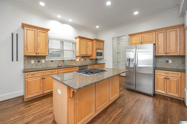 kitchen featuring a sink, stainless steel appliances, tasteful backsplash, a kitchen island, and dark wood-type flooring