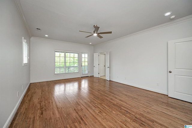 unfurnished room with crown molding, ceiling fan, baseboards, wood finished floors, and visible vents