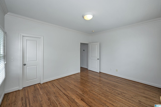 unfurnished room with baseboards, ornamental molding, and wood finished floors