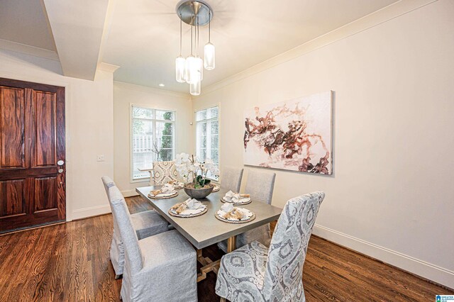 dining space featuring baseboards, ornamental molding, and dark wood-style flooring