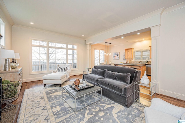 living room with crown molding, recessed lighting, baseboards, and wood finished floors