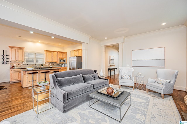 living room with recessed lighting, ornamental molding, light wood finished floors, and ornate columns