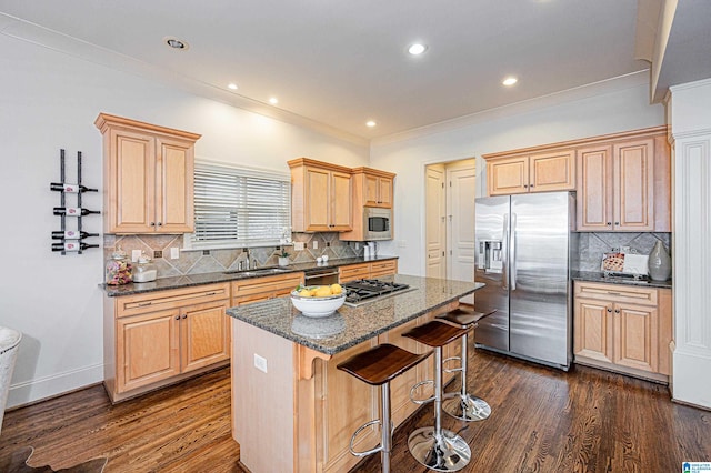 kitchen with appliances with stainless steel finishes, dark wood finished floors, tasteful backsplash, a kitchen island, and a kitchen bar