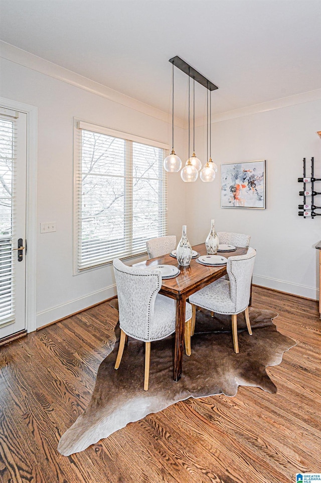 dining area with crown molding, baseboards, and wood finished floors
