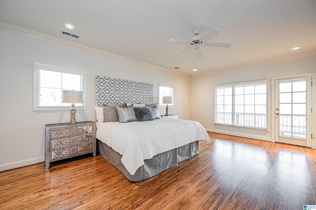 bedroom featuring baseboards, visible vents, ornamental molding, and wood finished floors