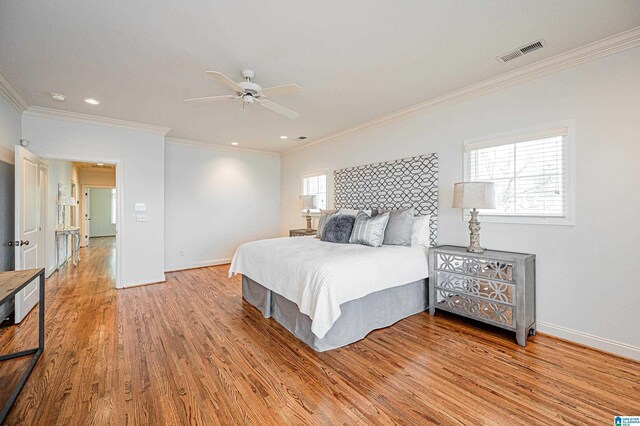 bedroom featuring visible vents, crown molding, light wood-type flooring, baseboards, and recessed lighting