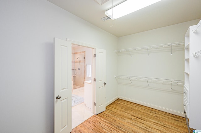 walk in closet featuring light wood-style floors, attic access, and visible vents