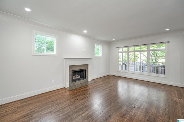 unfurnished living room featuring crown molding, baseboards, a fireplace with flush hearth, and dark wood-type flooring